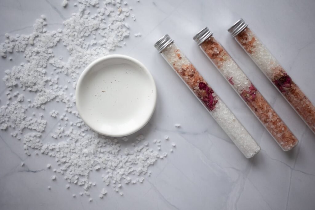 Aesthetic arrangement of bath salts with test tubes and dish, perfect for spa themes.