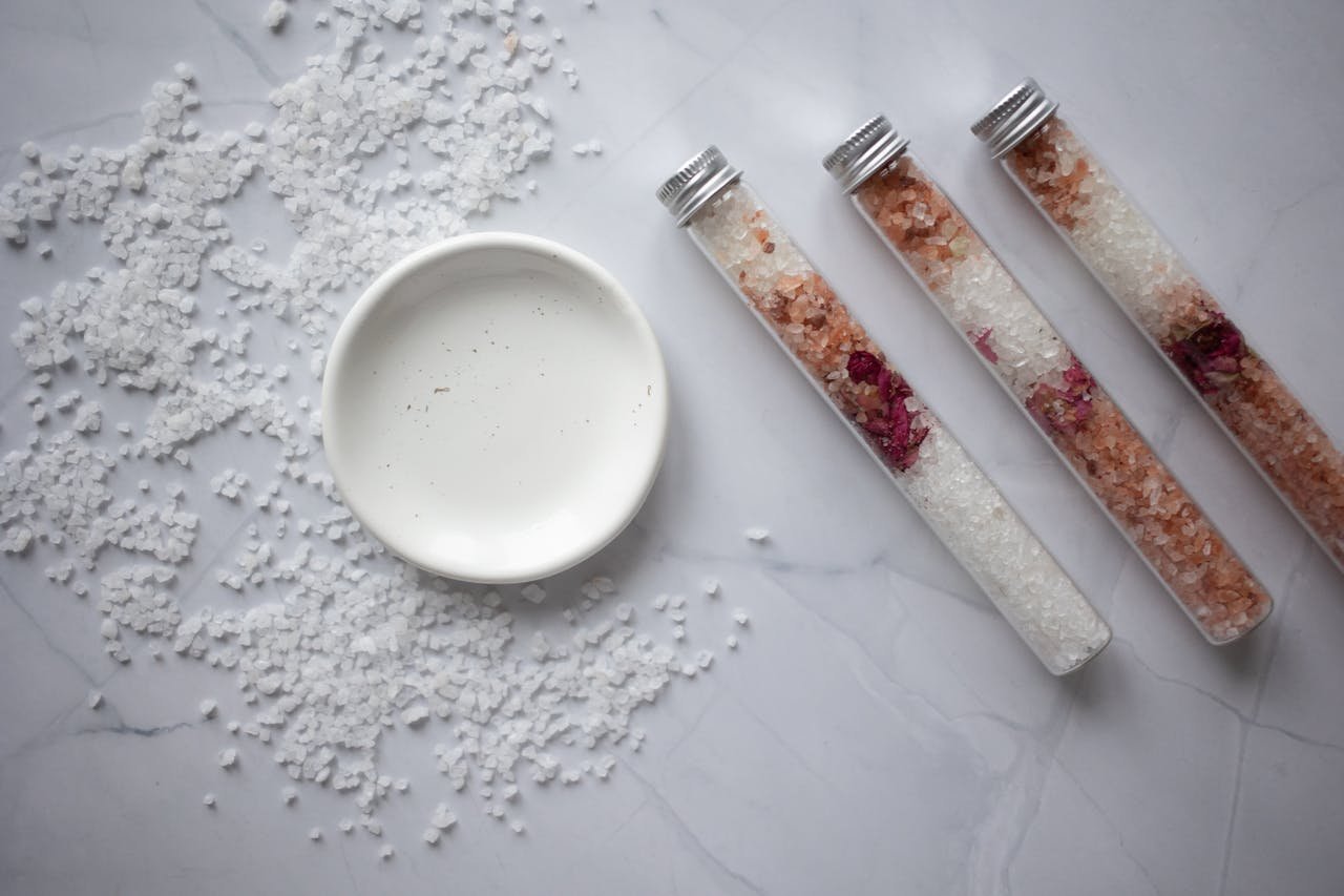 Aesthetic arrangement of bath salts with test tubes and dish, perfect for spa themes.