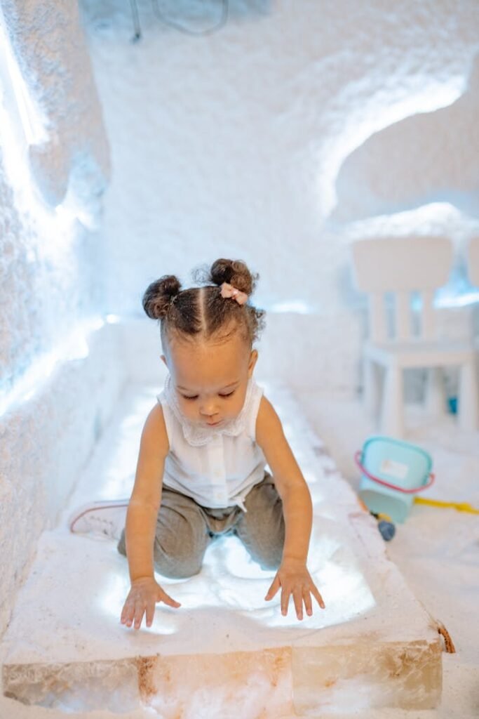 A cute toddler explores a salt room, engaging in sensory play indoors.